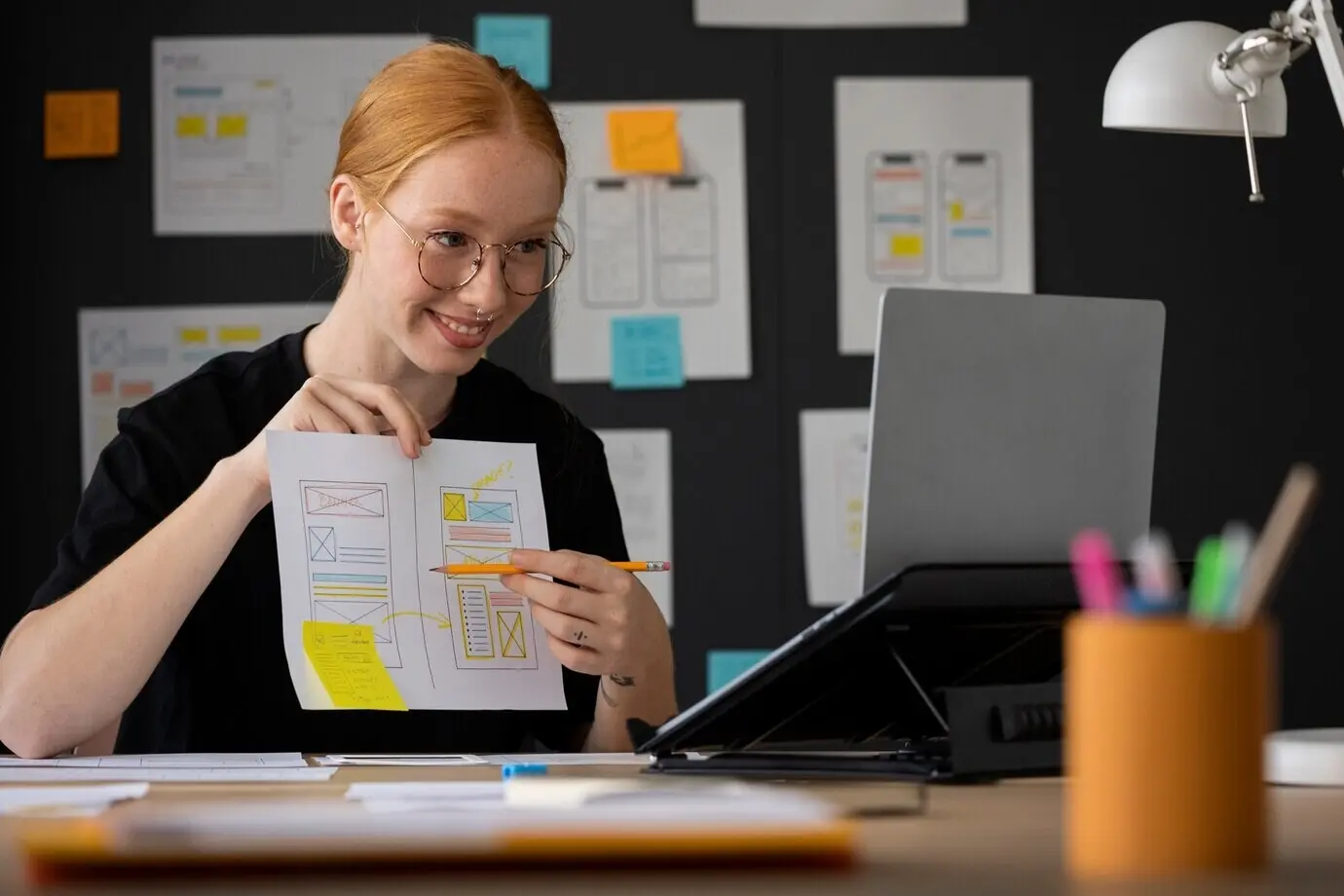 Webdesignerin im Büro mit Papieren und Notizen
